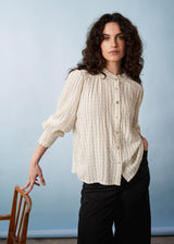 Fine detail textured high neck blouse with ruffle neck