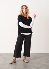 Black fine knit sweater and black wide leg raw hem cotton trousers