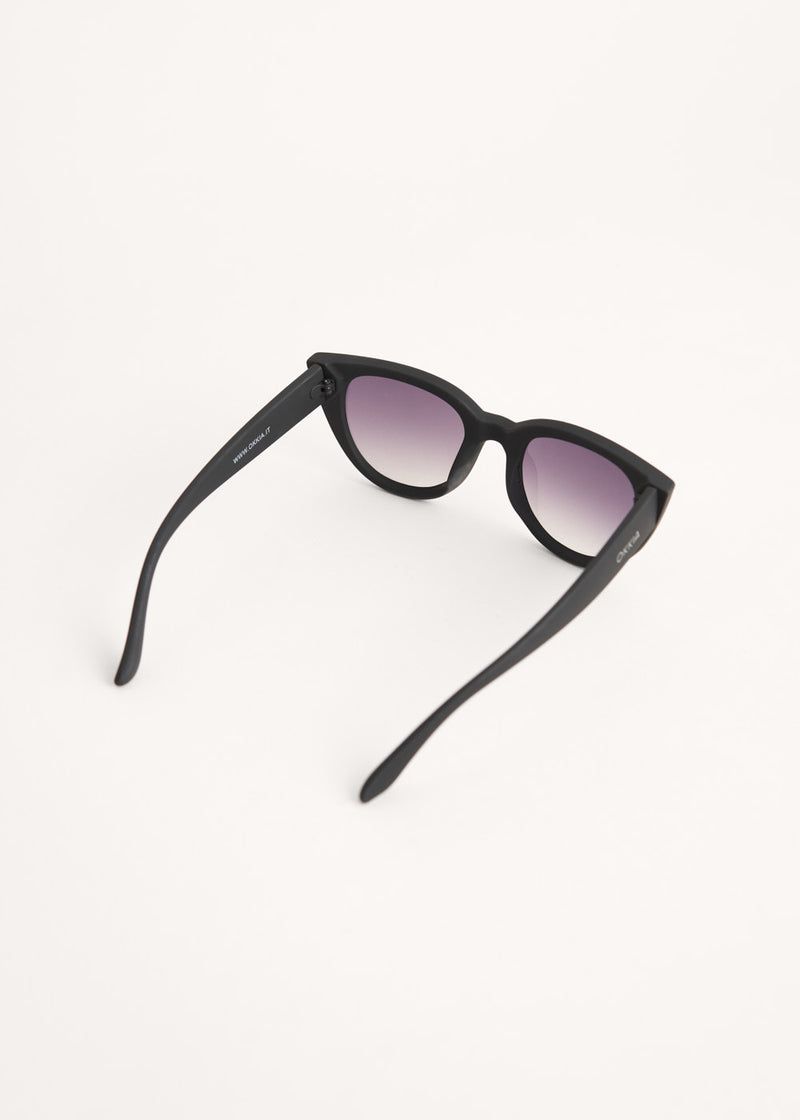 A pair of oversized cat eye sunglasses with black frames and blue lenses