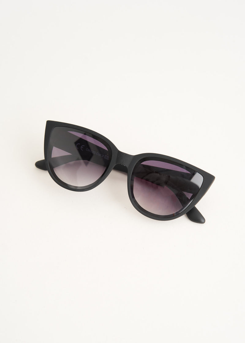 A pair of oversized cat eye sunglasses with black frames and blue lenses