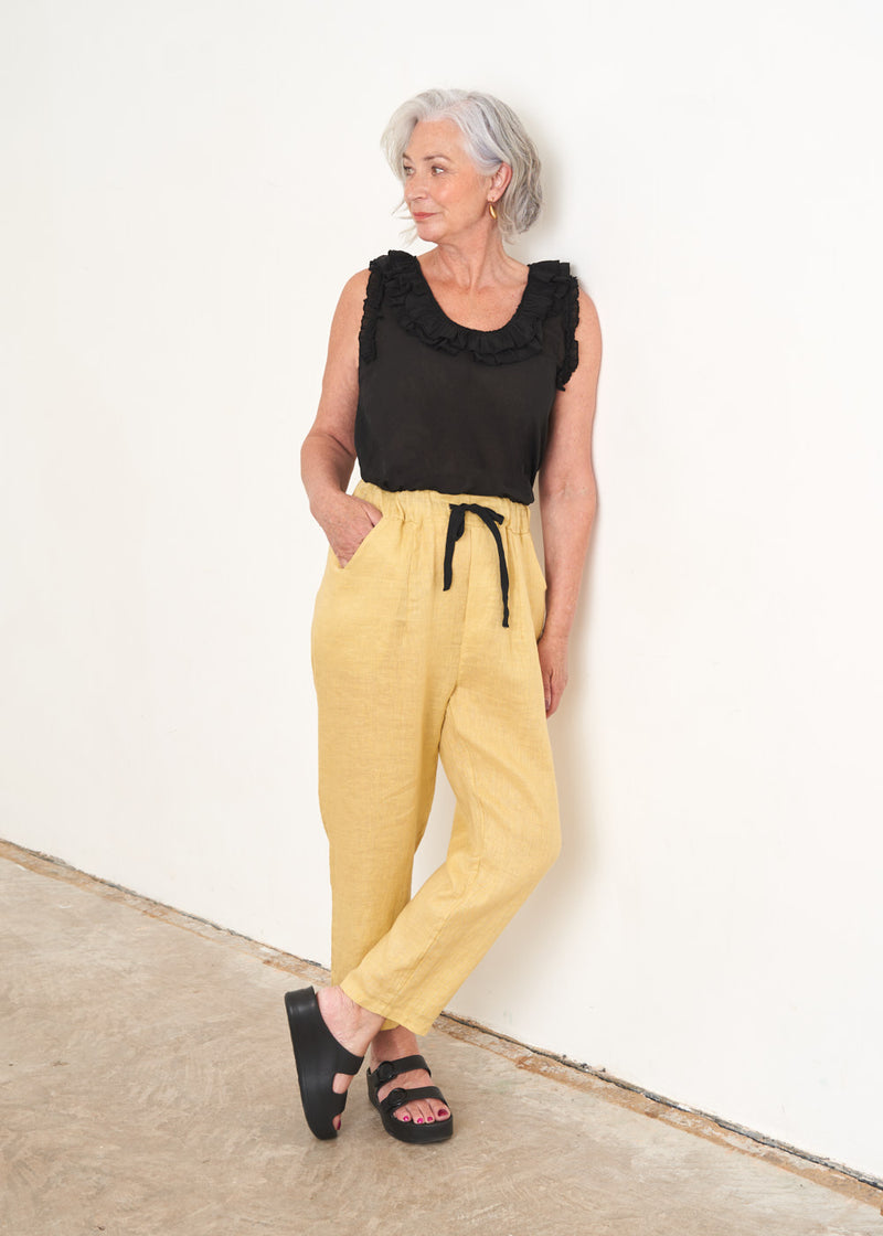 Black ruffle neck sleeveless top and Pale yellow linen drawstring trousers